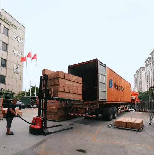 Packaged roll mattresses are being loaded into the container.